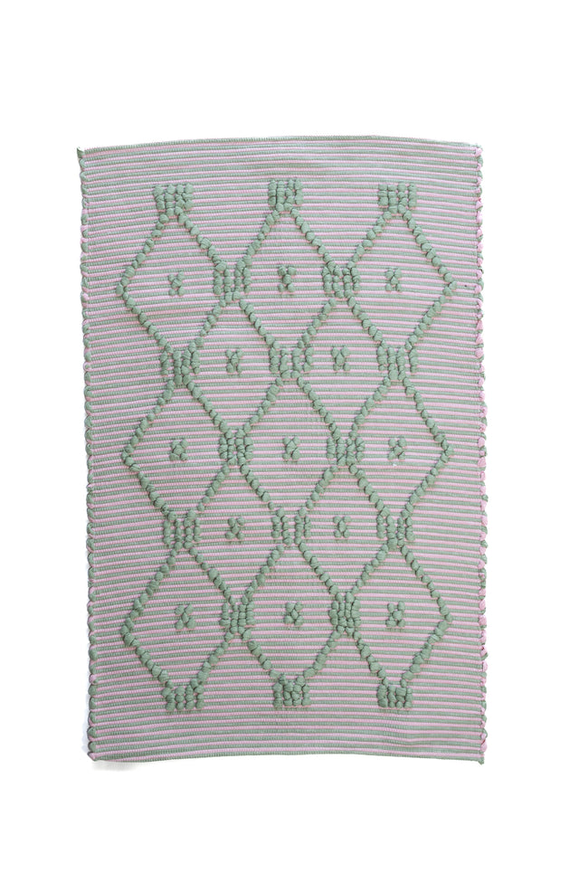 A madcap cottage pink and green striped accent rug with a lattice motif across the front