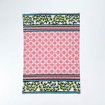 Christmas tea towel featuring a pink lattice pattern with green and white Chinoiserie-inspired borders