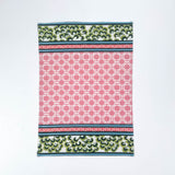 Christmas tea towel featuring a pink lattice pattern with green and white Chinoiserie-inspired borders