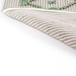 reverse of A pink/green accent rug with a lattice pattern on it