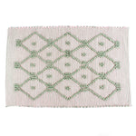 A pink/green accent rug with a lattice pattern on it