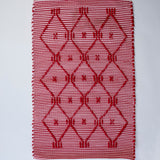 A madcap cottage white and red striped accent rug with a lattice motif across the front.