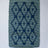 A madcap cottage navy blue and green striped accent rug with a lattice motif across the front