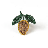  a lemon rattan napkin ring in the shape of a lemon with two green leaves against a white background