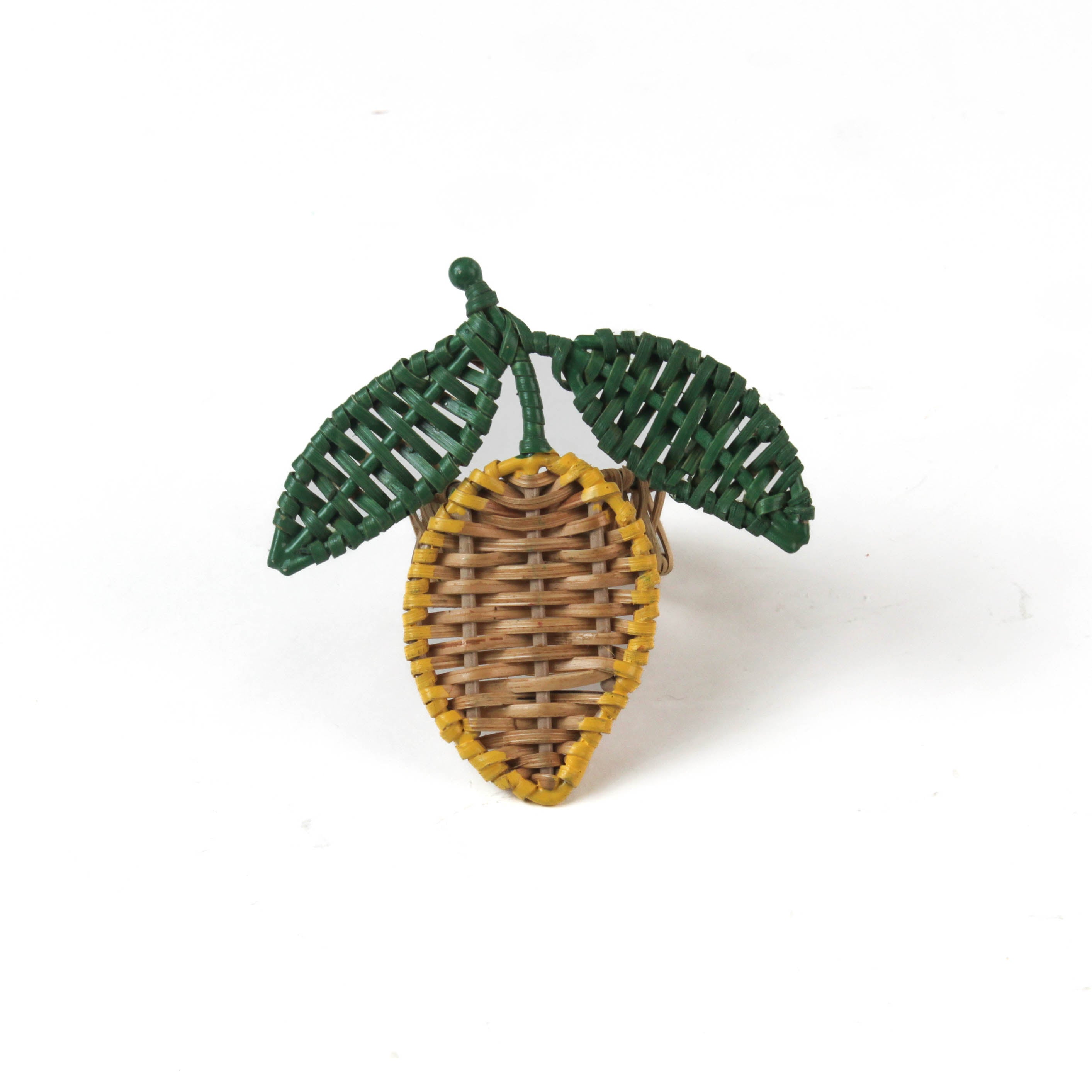 a lemon rattan napkin ring in the shape of a lemon with two green leaves against a white background