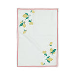 a white lemon tea towel with lemons in opposite corners and a red border resting against a white background. 