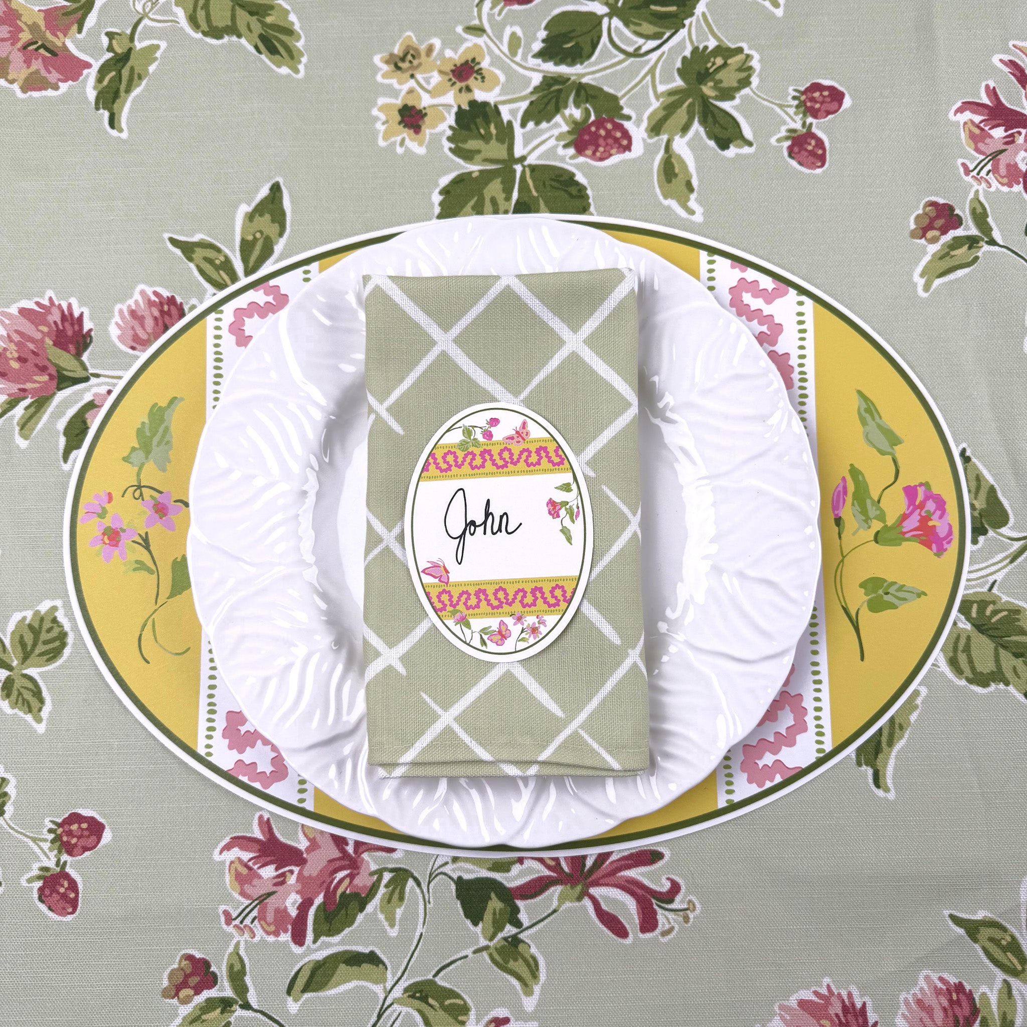 Easter egg Placemat with floral design, white plate, and green folded napkin on a matching tablecloth.