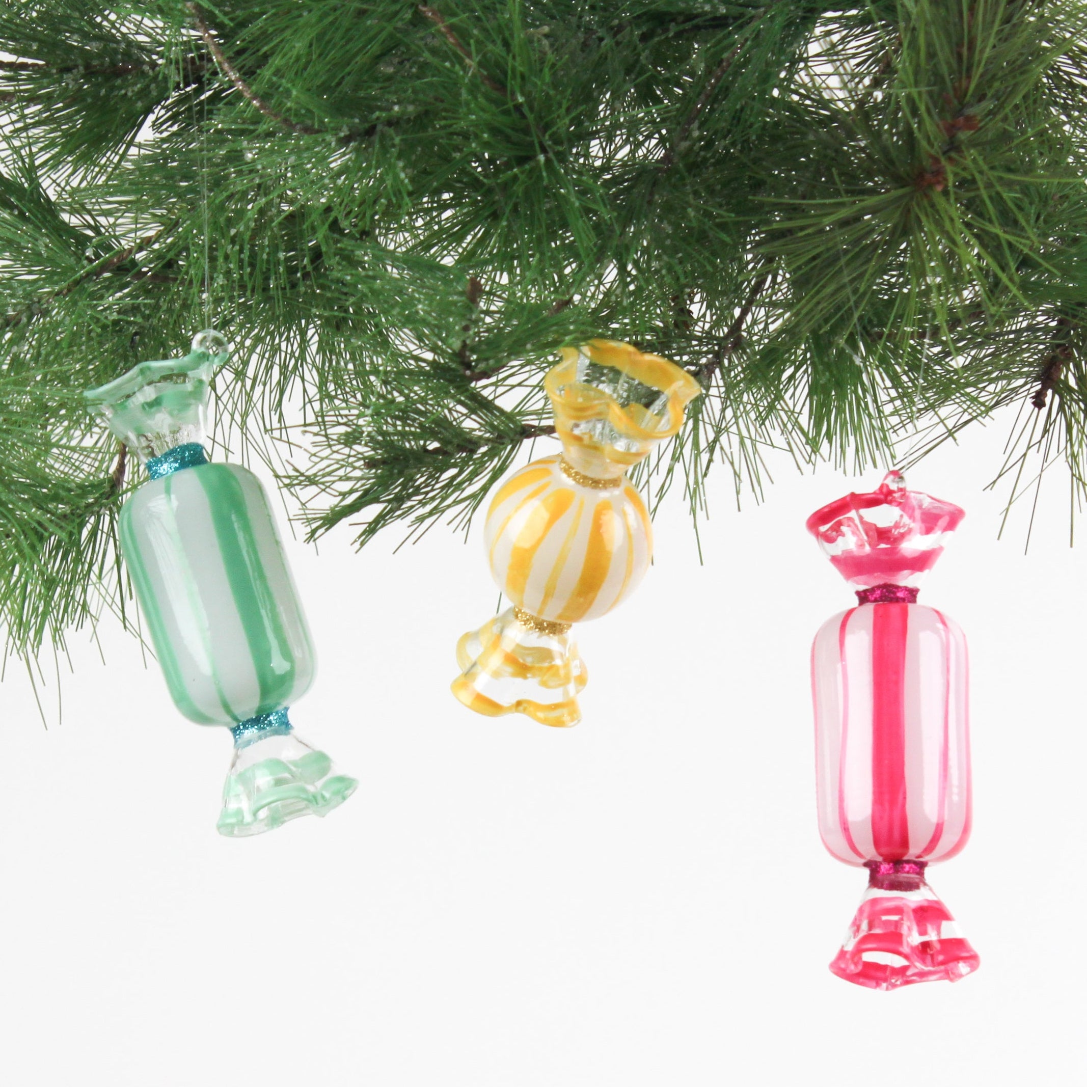 Colorful glass candy ornaments hanging on a Christmas tree.