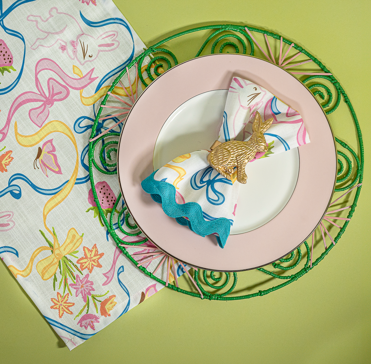 Lifestyle image of a multicolored Bunnies & Bow print cloth table runner and napkin in a bunny and bow print fabric.