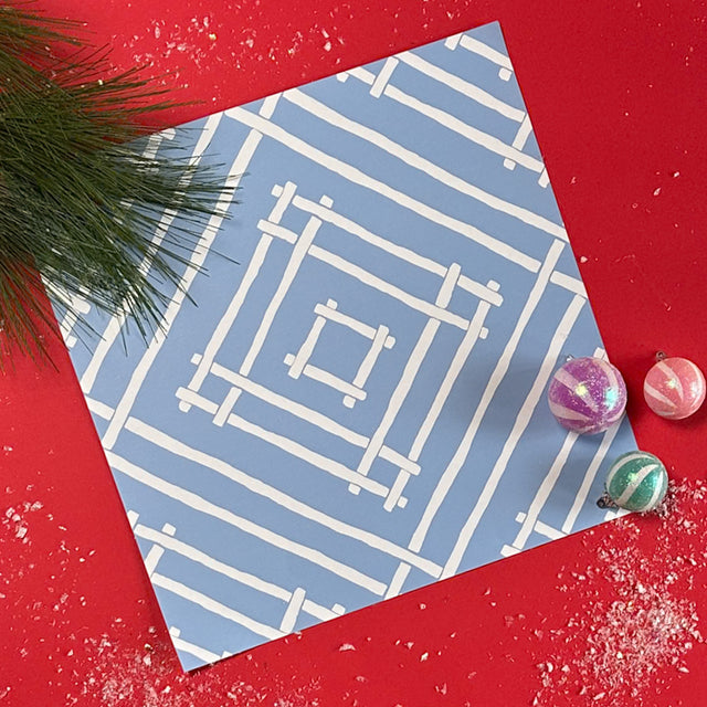 two square blue paper placemats with a white bamboo trellis design called "Island House" from Madcap Cottage.