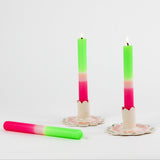 lit 2 Bright Pink Green Taper Candles  in a holder with white background