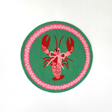 A round green and pink rug with a central red and pink lobster motif.
