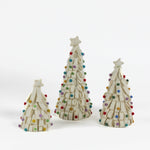 A set of three looped felt white christmas tree table decorations in graduating sizes from small to large with a white star on top and coloured felt ornaments dotted around the trees against a white background. 