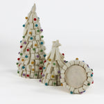 a looped felt white christmas tree table decoration iwith a white star on top and coloured felt ornaments dotted around the trees against a white background. 