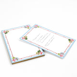 luxury christmas notepads with ornament and holly motifs against a white background.