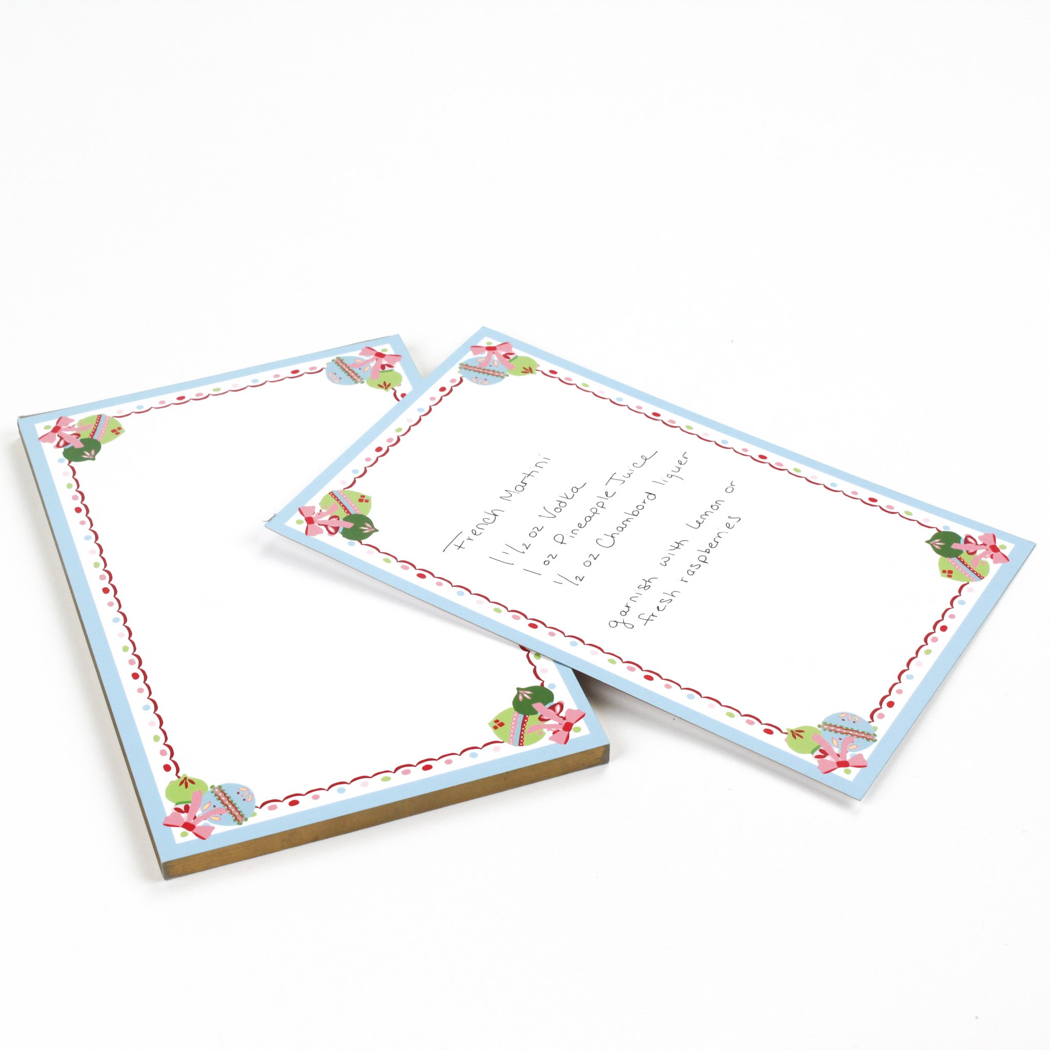 luxury christmas notepads with ornament and holly motifs against a white background.