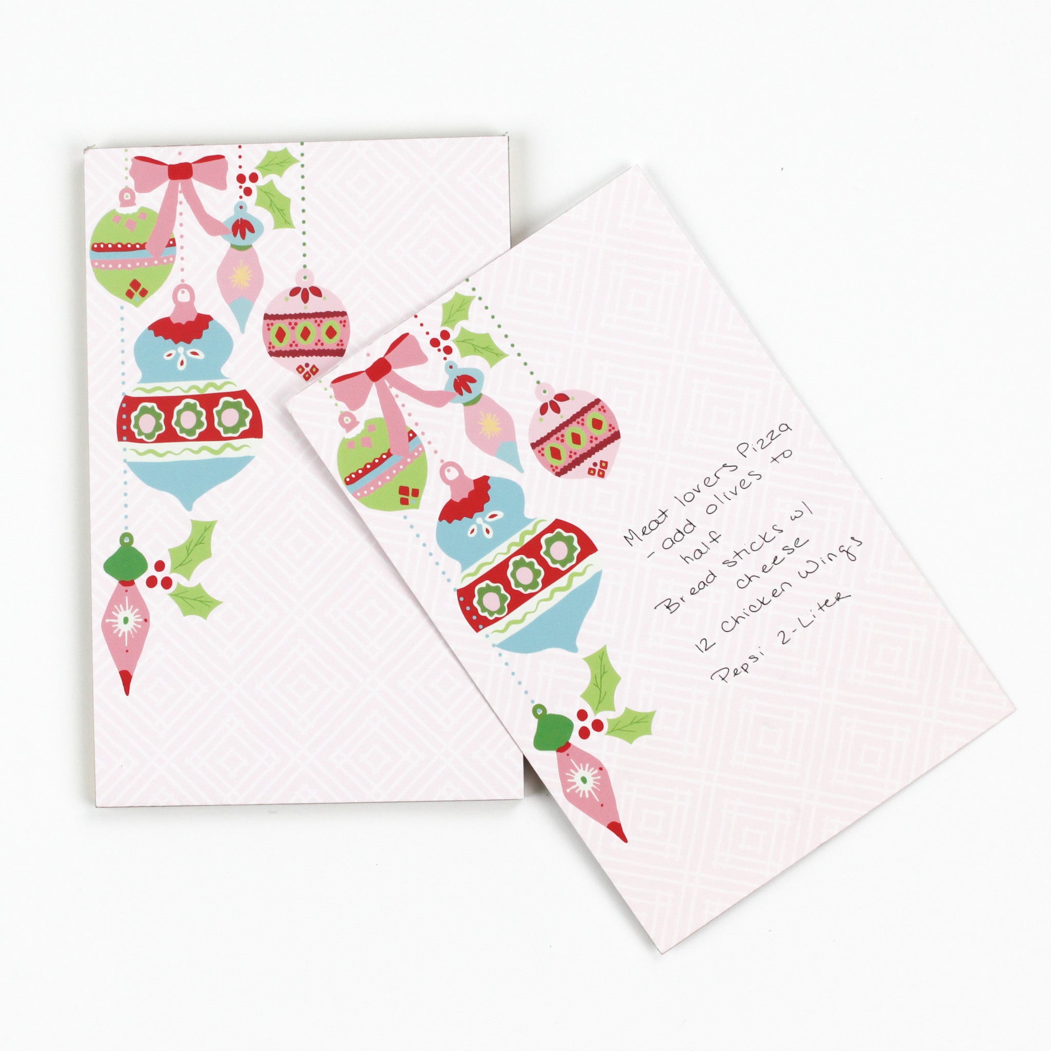luxury christmas notepads with ornament and holly motifs against a white background.
