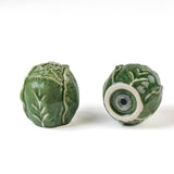 a pair of cabbage leaf salt and pepper shakers from madcap cottage, 1 showing the bottom