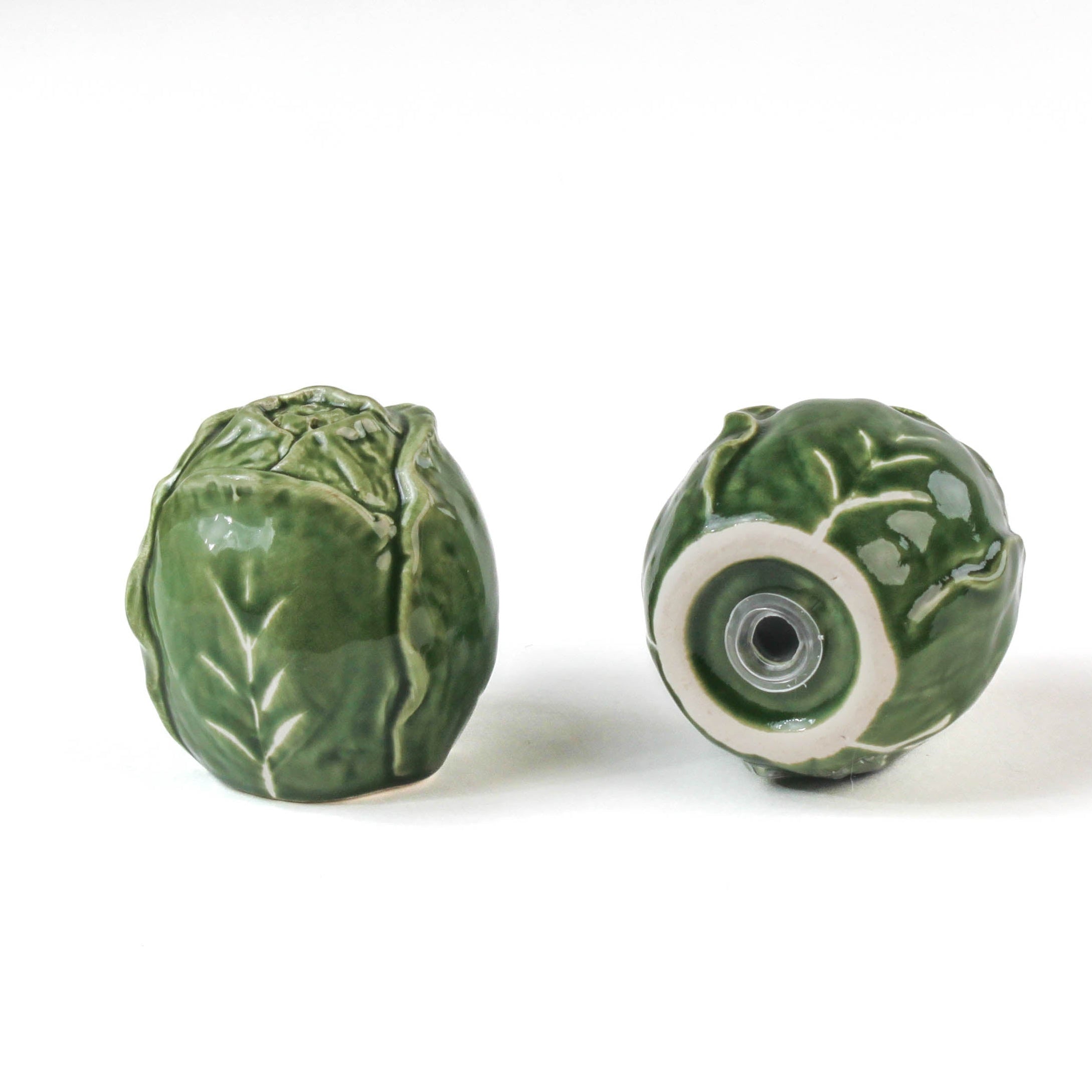 a pair of cabbage leaf salt and pepper shakers from madcap cottage, 1 showing the bottom
