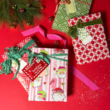 Three christmas gifts wrapped in colorful christmas wrapping paper from Madcap Cottage on a red background.