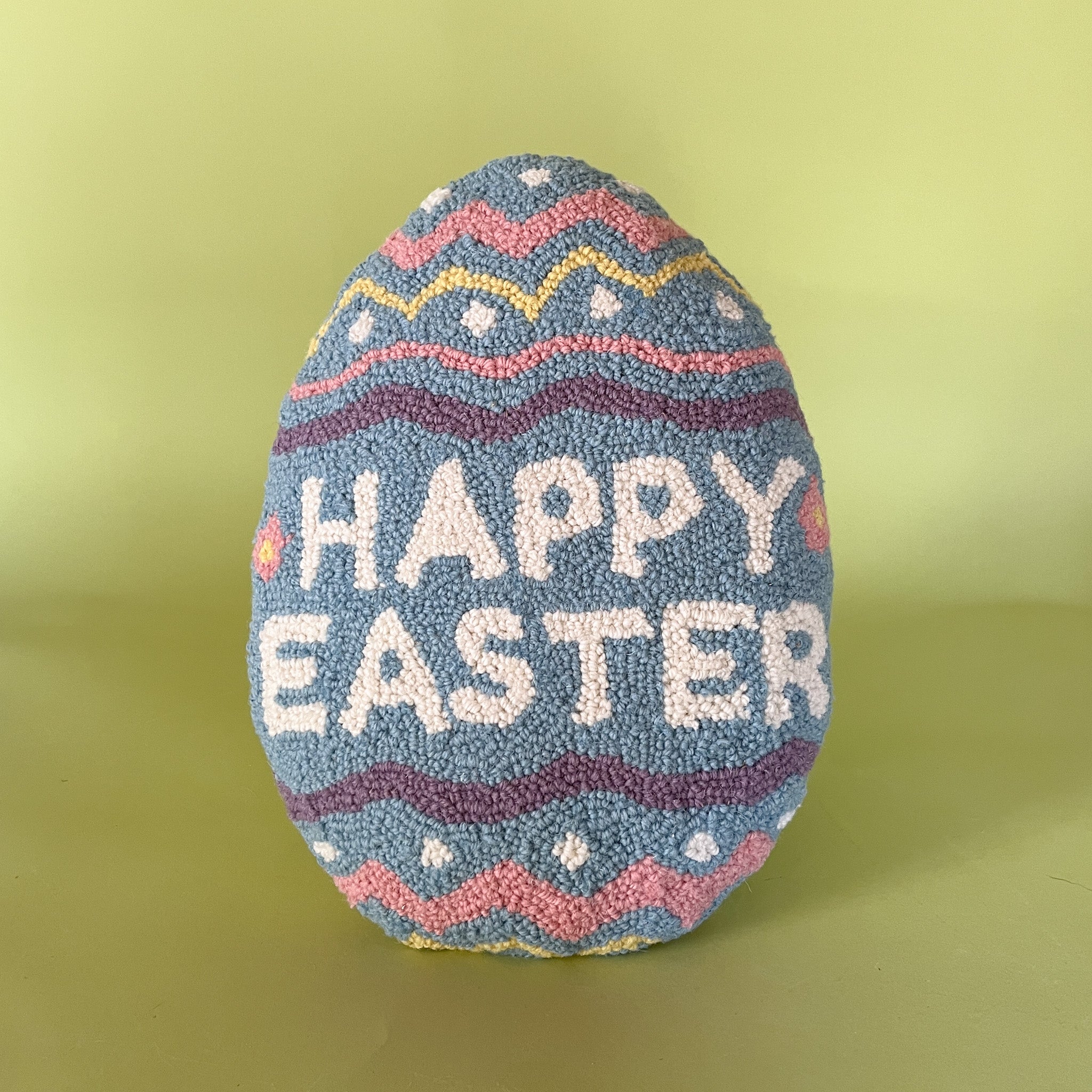 a purple easter egg pillow with text that reads "Happy Easter"