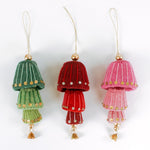 Three decorative felt christmas ornaments in green, red, and pink and gold sequin details on a white background