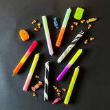 collection of taper candles on a black background, lying horizontally