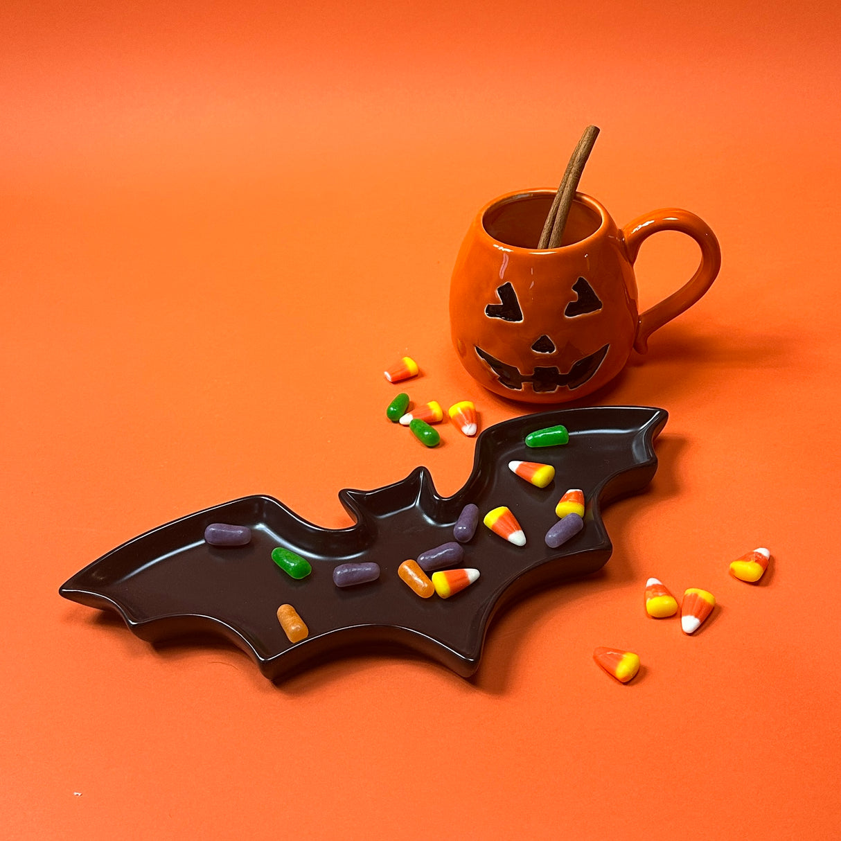 One ceramic mug with a jack o'lantern design, one with a handle