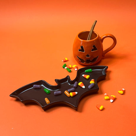 One ceramic mug with a jack o'lantern design, one with a handle