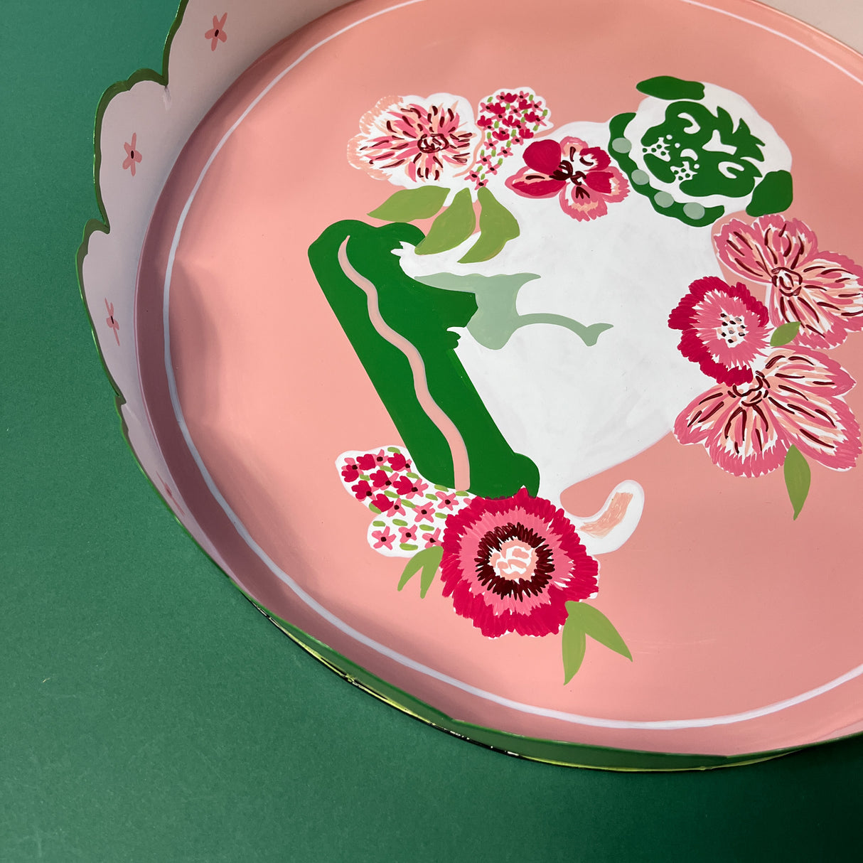 a pink and green tray featuring a scalloped border and floral pug motif