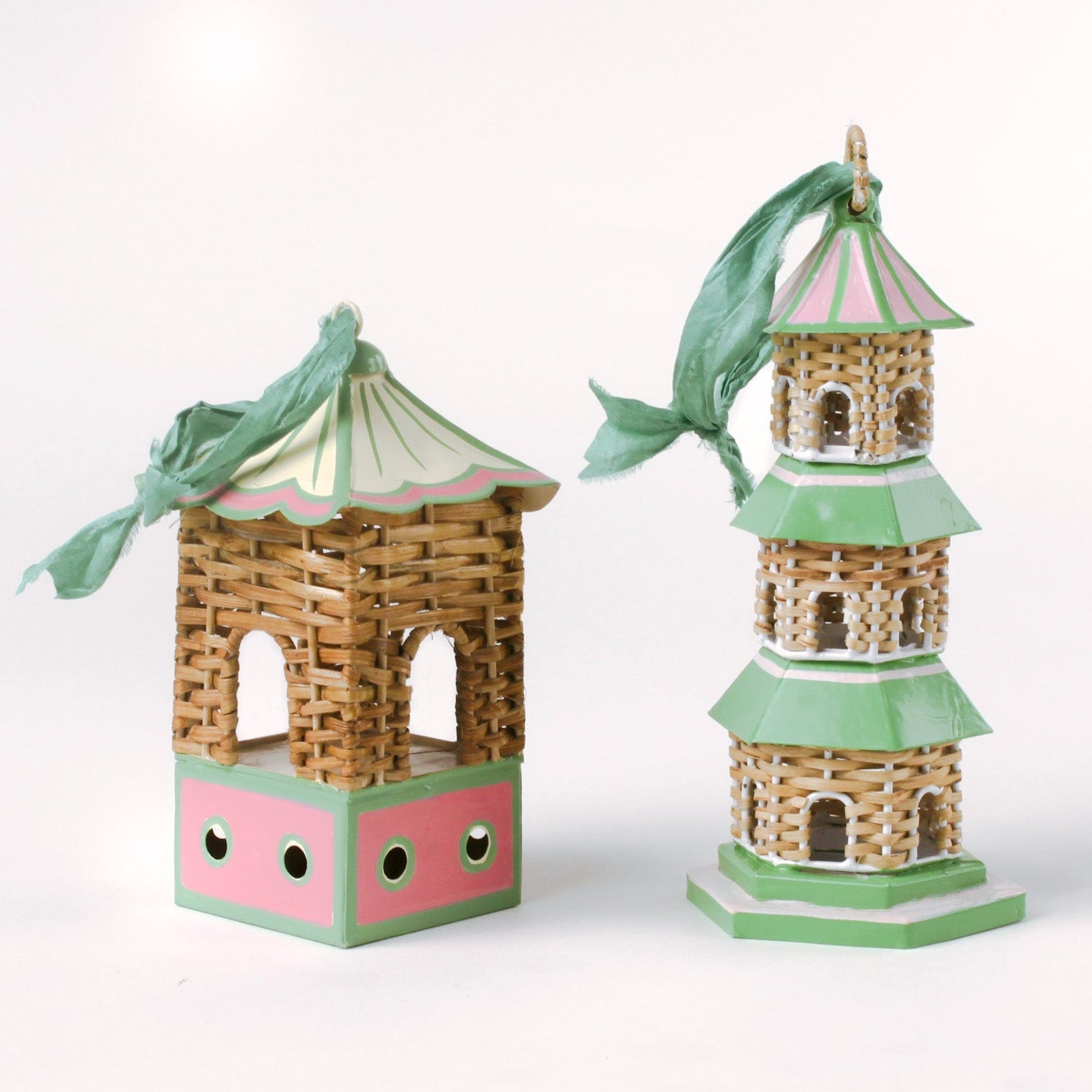 two miniature rattan pagoda chinoiserie christmas ornaments with green and pink painted accents from the brand madcap cottage on a white background. 