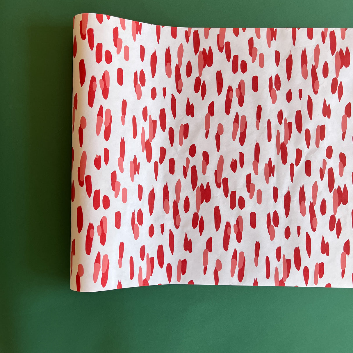 A white and red paper table runner featuring a brushtroke pattern called Club House by Madcap Cottage