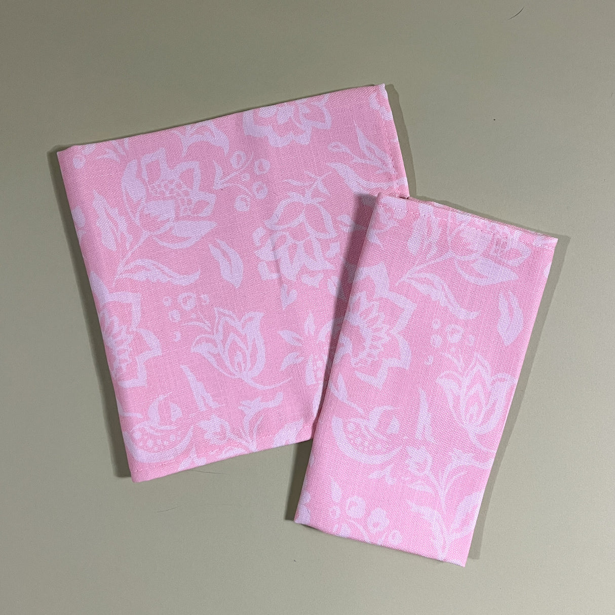 Hampton Court two shell pink cloth dinner napkins on a green background.