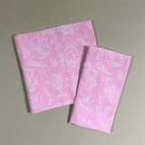 Hampton Court two shell pink cloth dinner napkins on a green background.