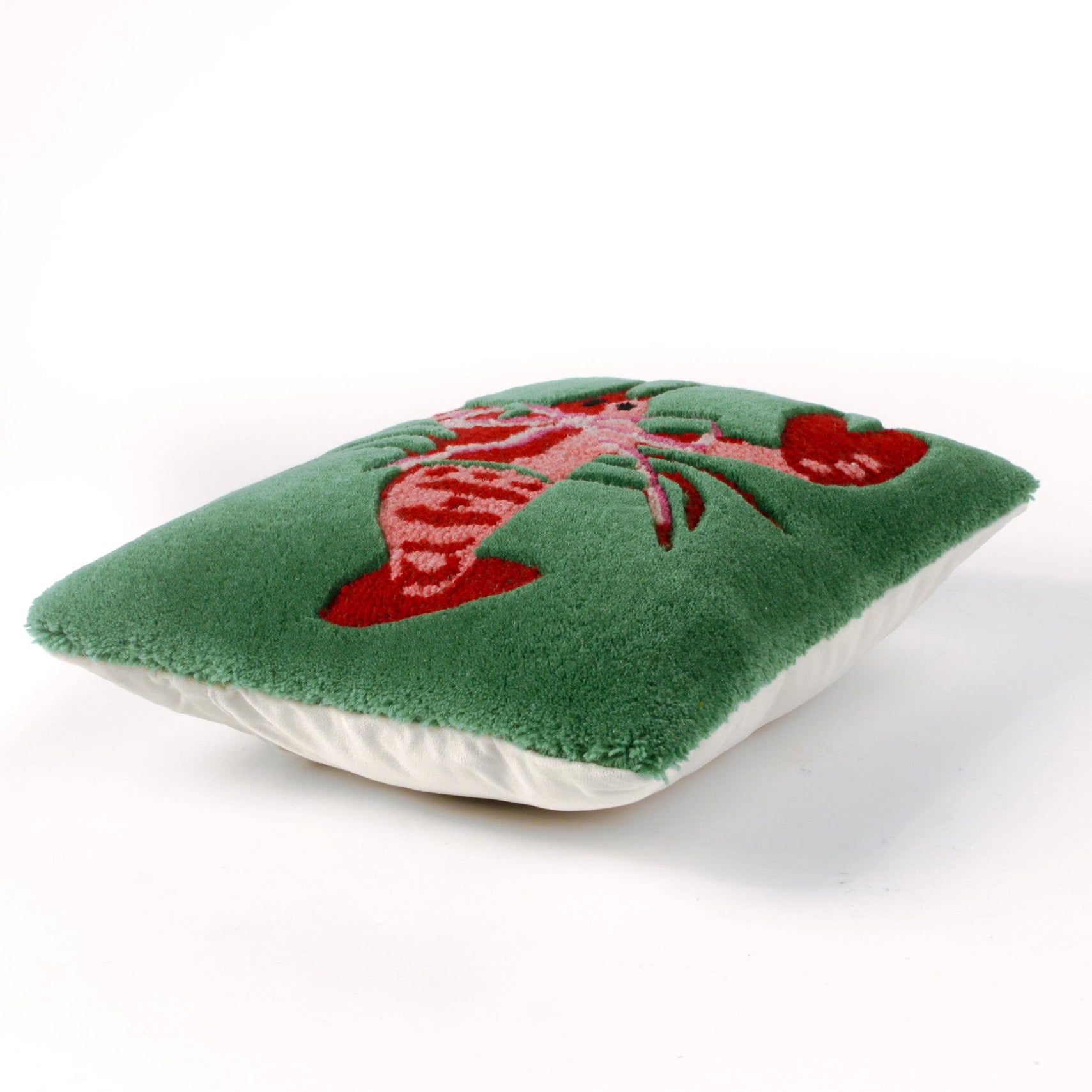 Pillow with a red lobster design on a green background from the madcap cottage designers. 
