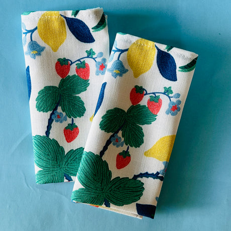 Strawberry Hill pair of cloth dinner napkin on a light blue background