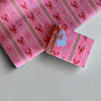 Pink wrapping paper featuring a blue ribbon and orange lobster motif