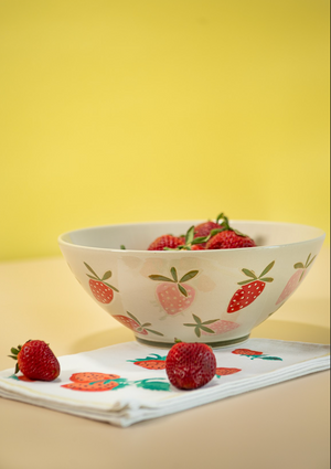 A large strawberry serving bowl with white and pink strawberry motifs decorating the exterior
