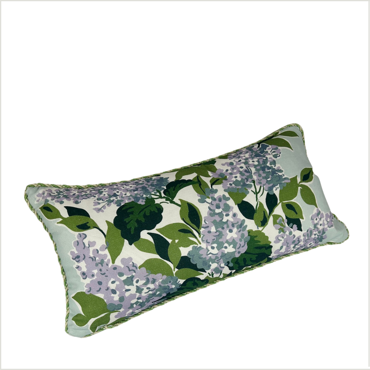 a light blue, rectangular throw pillow made from a fabric printed with mauve hydrangeas