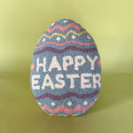 a purple easter egg pillow with text that reads "Happy Easter"