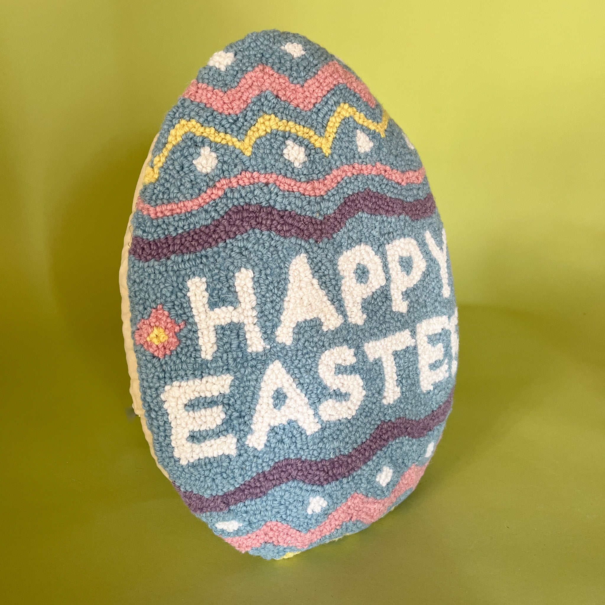 a purple easter egg pillow with text that reads "Happy Easter"