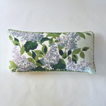white and green pillow with a hydrangea print and green piping.