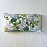 white and green pillow with a hydrangea print and green piping.