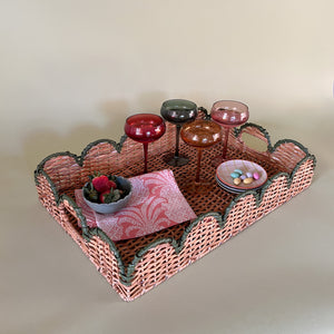 green rattan serving tray styled with champagne glasses side view