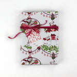 Cute Christmas wrapping paper decorated with white dancing mice holding ornaments and gift bags.