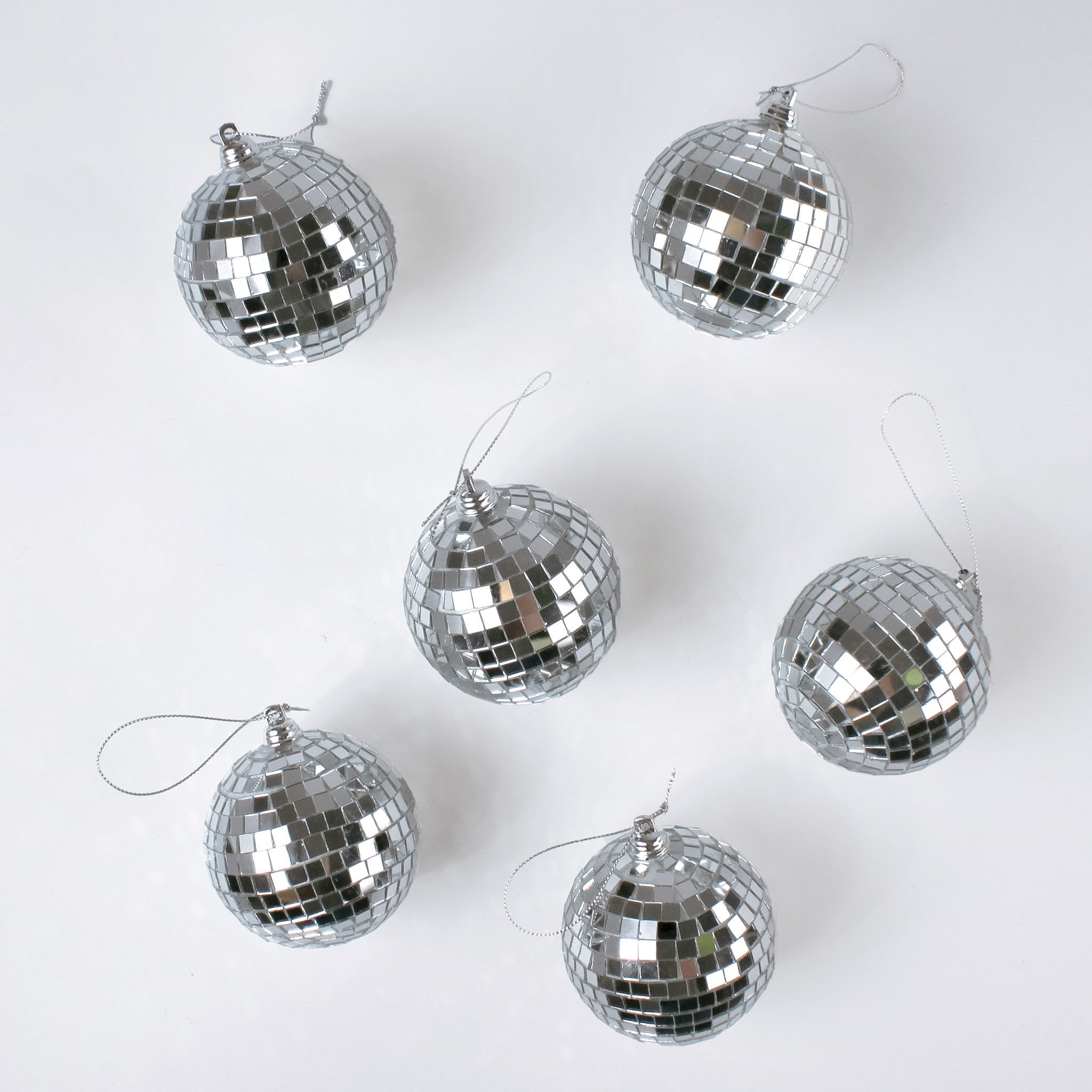 six silver disco ball christmas ornaments on a white background