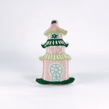 Decorative pillow shaped like a pagoda, featuring a pink base with green and white tiered roofs and intricate embroidered details in soft pastel colors.