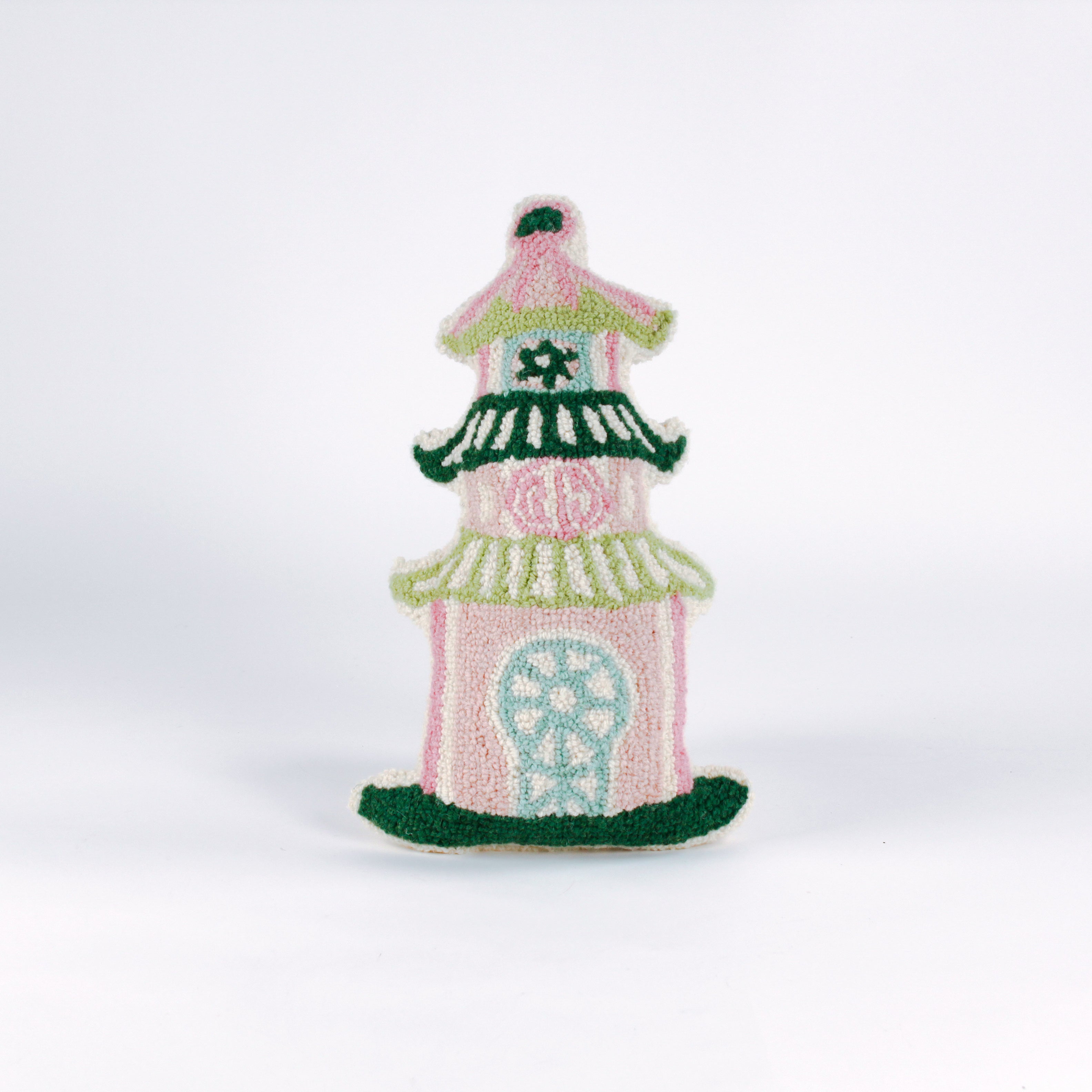 Decorative pillow shaped like a pagoda, featuring a pink base with green and white tiered roofs and intricate embroidered details in soft pastel colors.