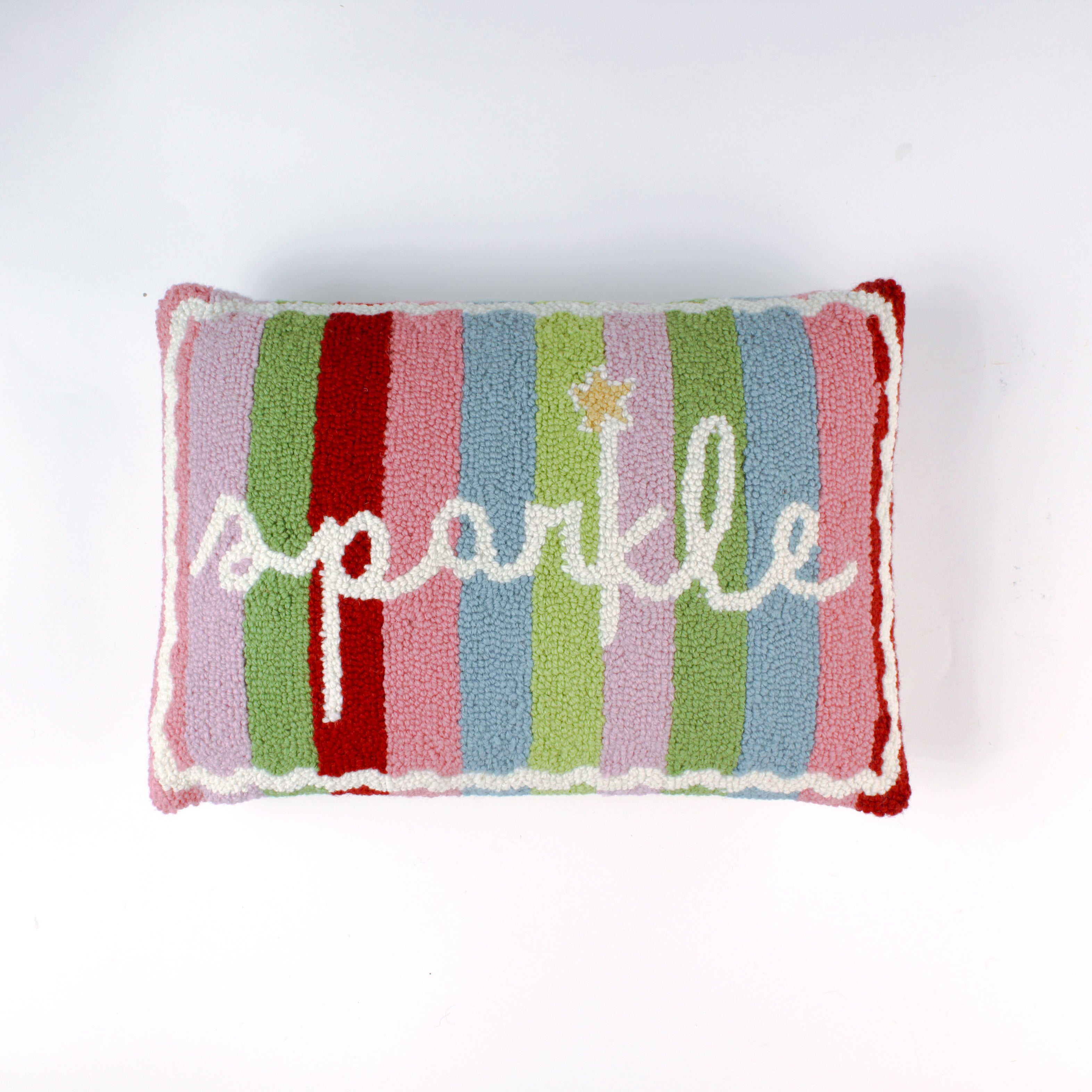 Rectangular colorful pillow with vertical stripes in red, pink, green, blue, and lavender, featuring the word “sparkle” written in white cursive with a small gold star above the letter “k.”