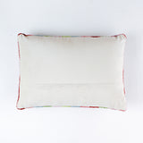back of a Rectangular pillow with colorful vertical stripes in red, pink, green, blue, and lavender, featuring the word “sparkle” written in white cursive with a small gold star above the letter “k.”